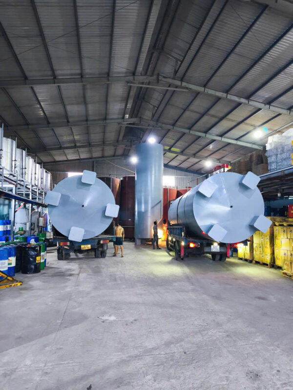 Xe tải chở thùng chứa công nghiệp lớn trong nhà xưởng sản xuất